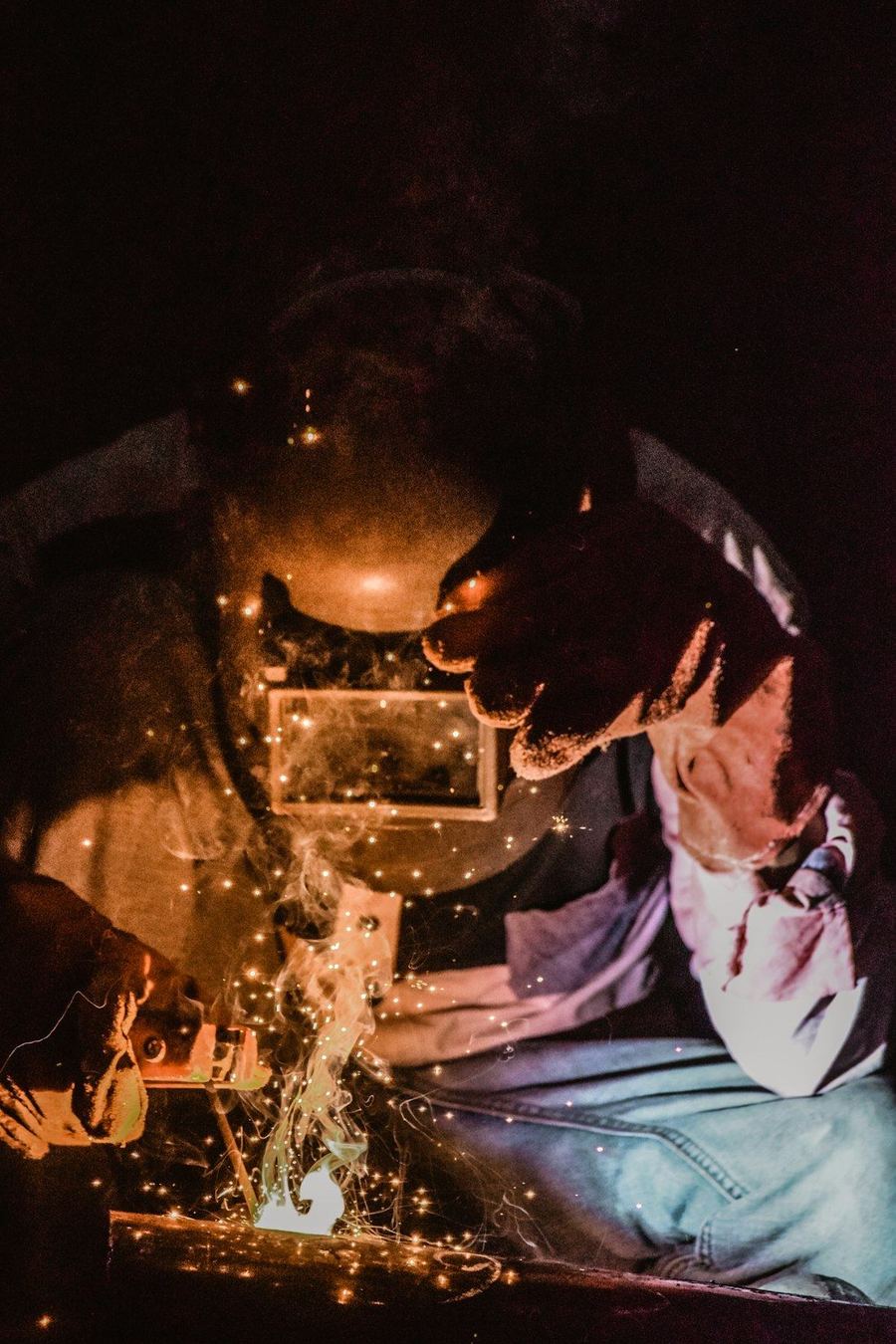 Metal parça üzerinde kaynak yapan usta