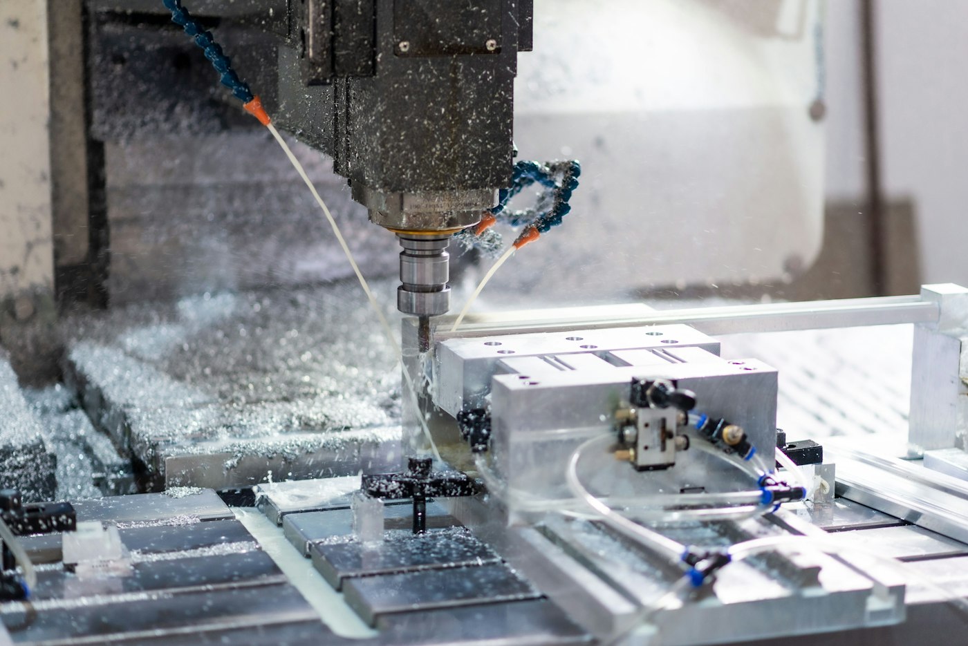 CNC işleme merkezinde soğutma sıvısı altında metal parçanın işlenmesi